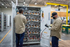 Power Storage Solutions technicians conducting preventative maintenance by testing batteries